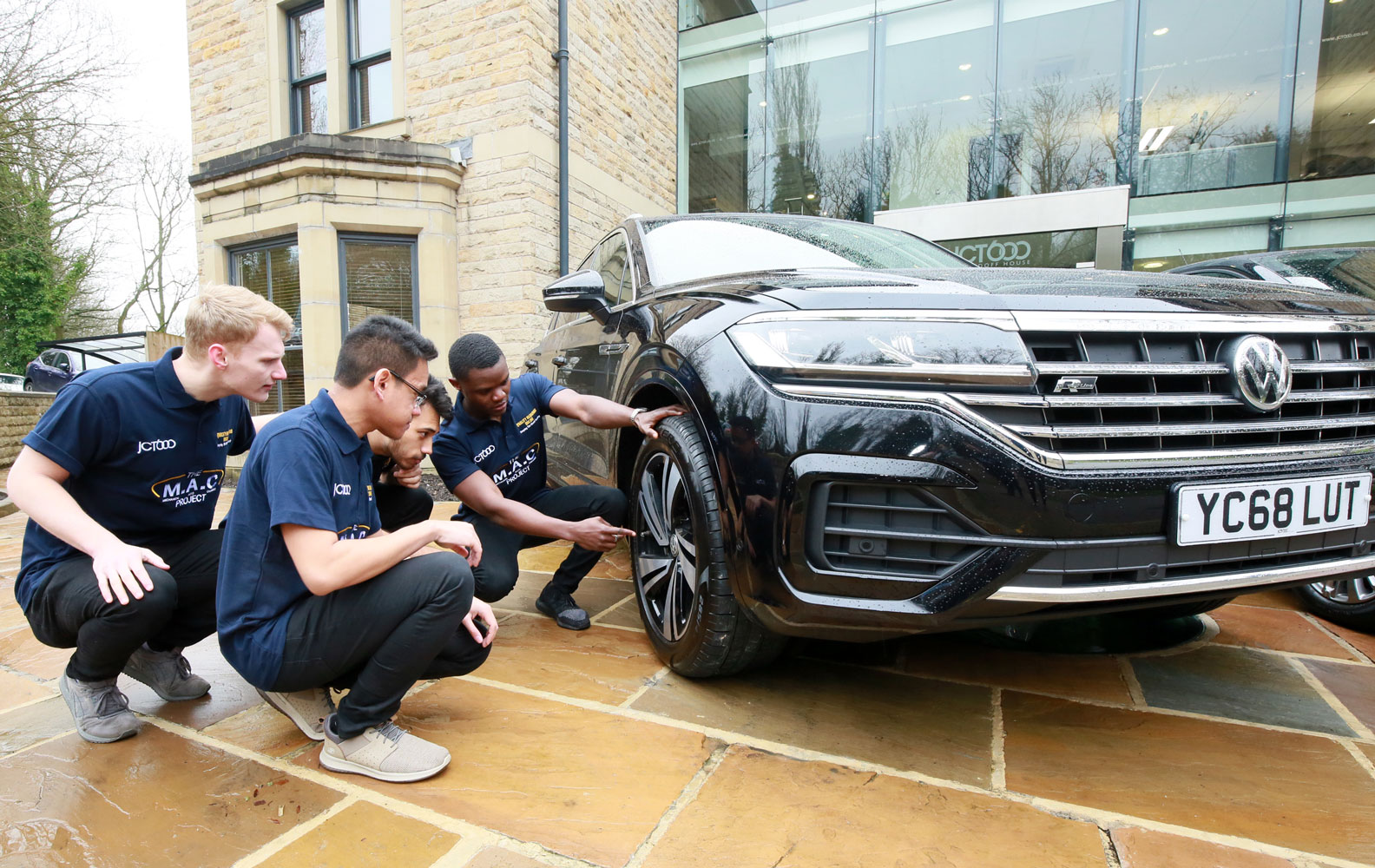 JCT600 engineering students inspecting a car wheel